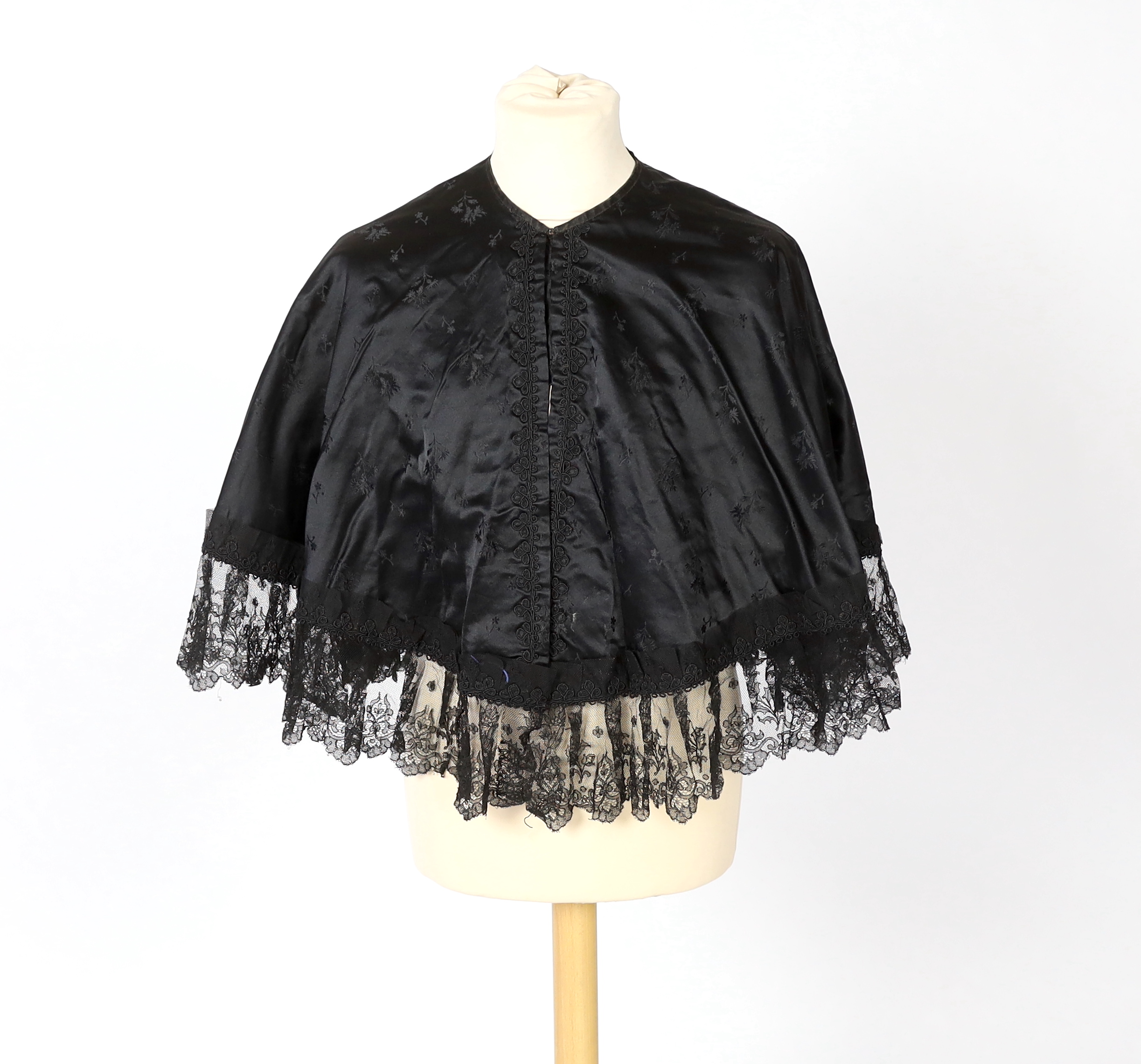 Two ladies Victorian black satin and lace, bead trimmed bodices, together with a black lace cape, a black satin cape, a small collection of coloured feathers and a child’s white worked pinafore